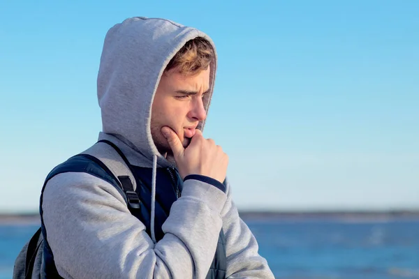 Junger Mann grübelnd, meditierend im Freien, trauriger gutaussehender Kerl an der Bucht und am Meer leidend. Kopierraum — Stockfoto