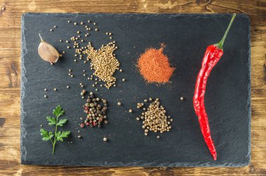 kırmızı sıcak biber biber, baharatlar, hardal, kişniş, maydanoz, sarımsak, tahta siyah arduvaz ve ahşap tahta Üstten Görünüm