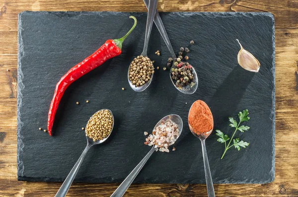 baharat kaşık ve kayrak ve ahşap üst görünümden arka plan üzerinde kırmızı biber Üstten Görünüm