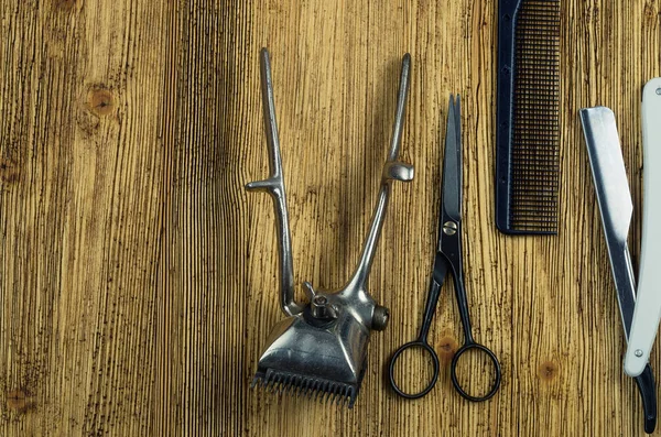 vintage hairdressing tools on a rough wooden surface free space on the left.