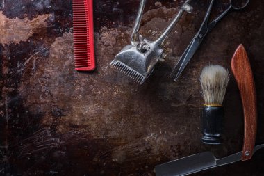 Eski, paslı bir yüzeyde eski berber aletleri..