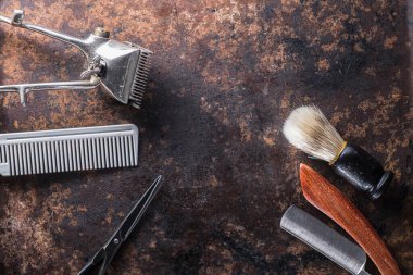 Eski, paslı bir yüzeyde eski berber aletleri..