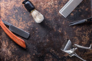 Eski, paslı bir yüzeyde eski berber aletleri..