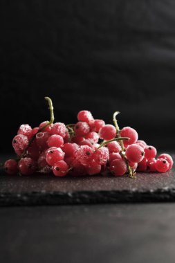 Donmuş böğürtlen üzümleri, levha tabaklarına saçılmış stoklanmış buzla kaplıdır..