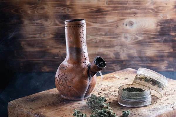 Oude bong en open cannabis molen met gehakte wiet en marihuana in rook — Stockfoto