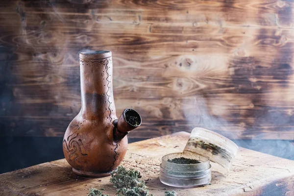 Oude bong en open cannabis molen met gehakte wiet en marihuana in rook — Stockfoto