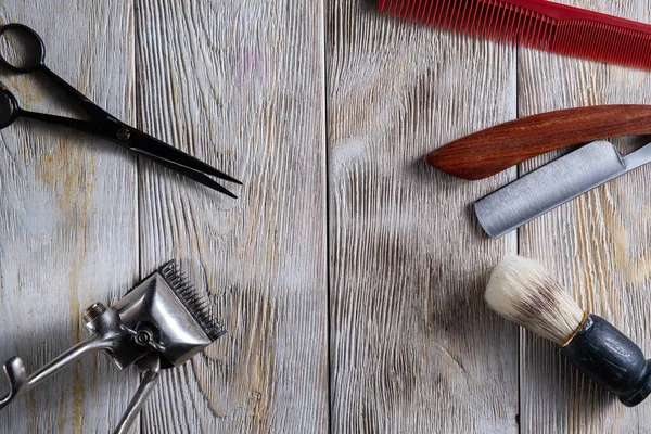 Hairdressing scissors vintage manual clipper comb brush dangerous razor are on a white weathered wooden surface. — Stock Photo, Image