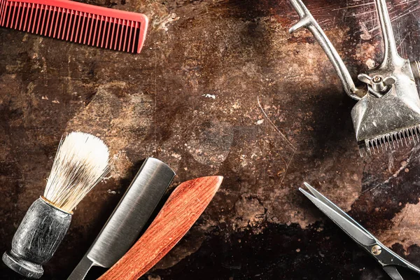 Перукарські ножиці старовинні ручні затискачі гребінці небезпечні бритви знаходяться на іржавій старій красивій поверхні . Стокове Фото
