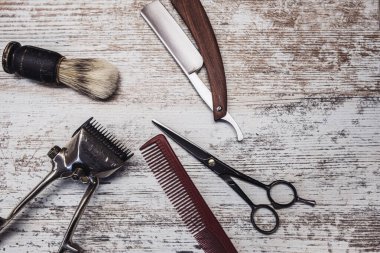 vintage barber tools dangerous razor hairdressing scissors old manual clipper comb shaving brush. old white weathered wood background. clipart