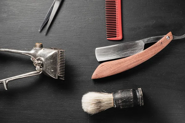 Vintage barber tools dangerous razor hairdressing scissors old manual clipper comb shaving brush. old black background. — Stock Photo, Image