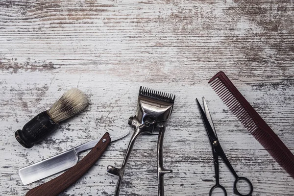 Outils de barbier vintage rasoir dangereux ciseaux de coiffure vieille tondeuse manuelle peigne brosse à raser. vieux fond blanc en bois altéré . — Photo