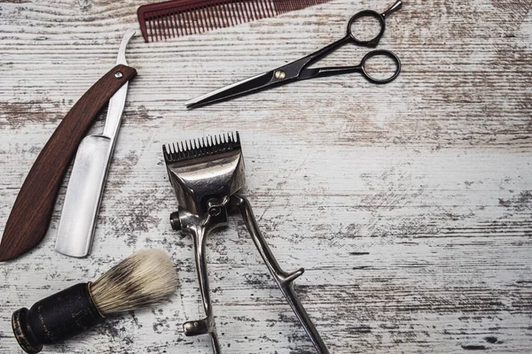 Outils de barbier vintage rasoir dangereux ciseaux de coiffure vieille tondeuse manuelle peigne brosse à raser. vieux fond blanc en bois altéré . — Photo