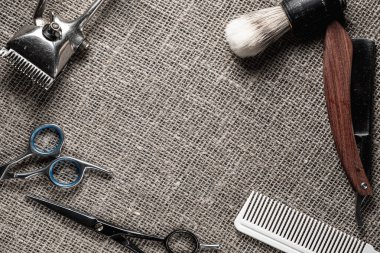 vintage barber tools dangerous razor hairdressing scissors old manual clipper comb shaving brush. on sackcloth background.