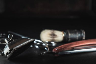 Siyah arka planda klasik berber malzemeleri. Profesyonel kuaför aletleri. Makas, manuel saç makasi, ustura, traş fırçası. Boşluğu kopyala