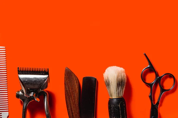 Old barber tools on an old beautiful Lush Lava surface. A razor, shaving brush, comb, hairdressers scissors, and a clipper. horizontal orientation. copy space