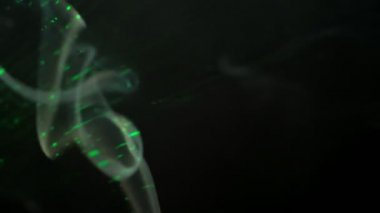 flowing smoke is illuminated by laser beams in the dark