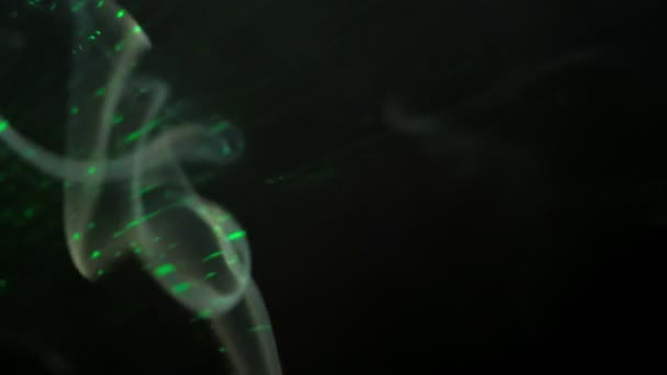 La fumée qui coule est éclairée par des rayons laser dans l'obscurité — Video