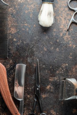 Klasik berber aletleri tehlikeli jilet, kuaför makası, eski manuel makas, metal tarak, tıraş fırçası. Eski paslı metal arka plan. Dikey yönelim. Üst görünüm, düz uzanma.