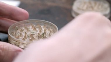 Paslı bir arka planda eski bir öğütücüde marihuana öğütmek