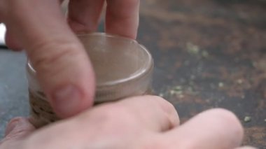 Paslı bir arka planda eski bir öğütücüde marihuana öğütmek
