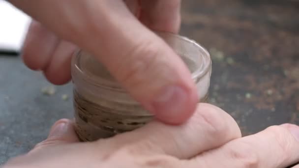 Grinding marijuana in an old grinder on a rusty background — Stock Video