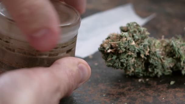 Marihuana vermalen in een oude molen bij de knop van medicinale cannabis op een roestige achtergrond — Stockvideo