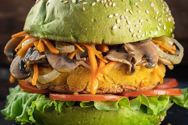 veggie burger. lettuce, the cutlet vegetarian meat alternatives consists of chickpeas corn potatoes, fried onions and carrots. mushrooms with fried onions and carrots. rusty baking stick. wooden background. Horizontal orientation. close up