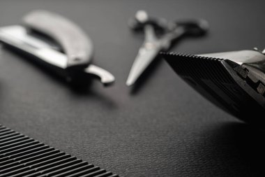 Siyah yüzey eski berber aletleridir. İki klasik manuel saç makası, jilet, tıraş fırçası, kuaför makası. siyah monokrom. yatay yönelim.