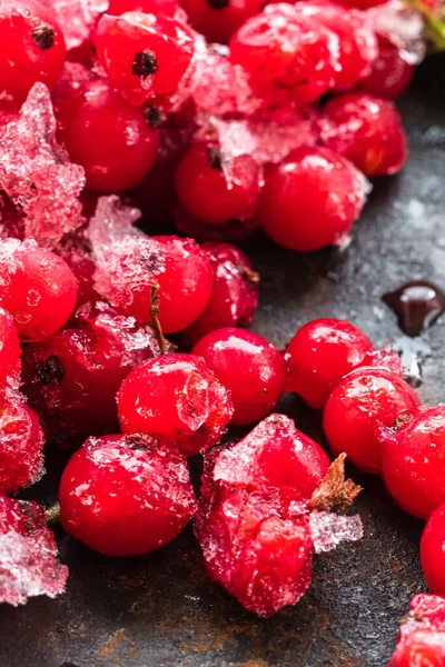 Las grosellas rojas congeladas se encuentran en una superficie oxidada. vertical . —  Fotos de Stock