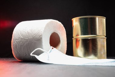 kırmızı dramatik çerçeve. rulo tuvalet kağıdı, iki kutu konserve yiyecek ve tıbbi maske koronavirüs virüsü koruması. Yatay. koyu arkaplan.