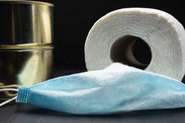 rulo tuvalet kağıdı ve iki kutu konserve yiyecek ve tıbbi maske koronavirüs virüsü koruması.