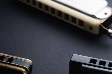 Koyu arkaplanda iki diyatonik ve krom mızıka. Yatay oryantasyon. Boşluğu kopyala