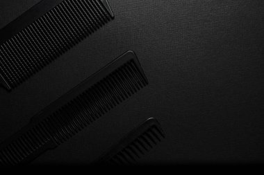 Siyah bir yüzeyde eski berber aletleri vardır. Berber aletleri. Üç tarak. siyah monokrom. Çerçeve Üst görünüm yatıyordu. Boşluğu kopyala