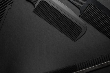 Siyah bir yüzeyde eski kuaför aletleri vardır. Taraklar. siyah monokrom. yatay oryantasyon. Üst manzara düz ley. Boşluğu kopyala.