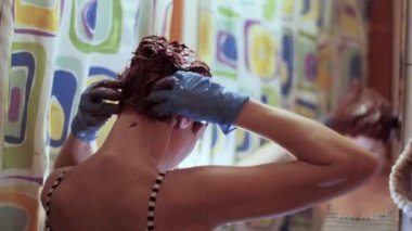 Kendini izole ederken kadın kuaför saçını turuncuya boyar. 4k