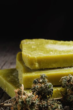 Eski paslı metal damlayan tavada rustik kenevir yağı ve tıbbi marihuana tomurcuğu. Eski ahşap arka plan. yatay oryantasyon. yakın plan.