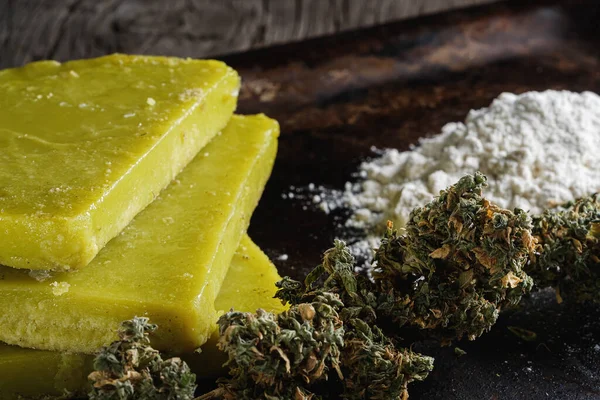 rustik kenevir yağı ve tıbbi marihuana tomurcuğu ve eski paslı metal damlatma tavasında un. Eski ahşap arka plan. yatay oryantasyon. yakın plan.