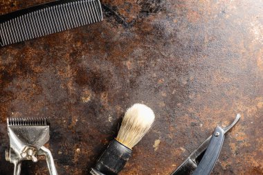 Paslı bir yüzeyde eski kuaför aletleri vardır. Manüel makas, tarak, jilet, tıraş fırçası. Kırsal kesim. yatay oryantasyon. Üst manzara düz ley. Boşluğu kopyala.