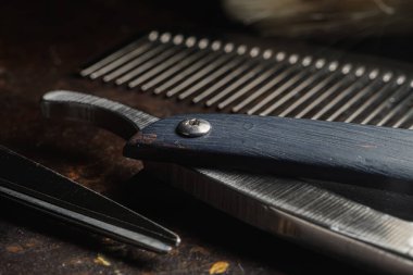 Paslı bir yüzeyde eski kuaför aletleri vardır. Makas, tarak, jilet, yaklaşın. Kırsal kesim. yatay oryantasyon. Boşluğu kopyala.