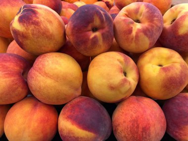 Sarı şeftali sergilenirken yaklaş, mükemmel şeftali. Kırmızı, pembe ve altın renkleri ile tüylü ince derileriyle ayırt edilirler.. 