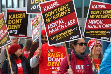 Oakland, Ca - 17 Aralık 2019: Broadway 'deki Kaiser Tıp Merkezi' nin önünde kimliği belirsiz sağlık görevlileri protesto ediyor. Endişeler arasında düşük ücretler, Kaiser yöneticileri için yüksek maaş ve personel sıkıntısı yer alıyor.