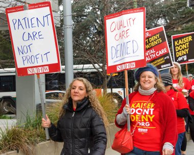 Oakland, Ca - 17 Aralık 2019: Broadway 'deki Kaiser Tıp Merkezi' nin önünde kimliği belirsiz sağlık görevlileri protesto ediyor. Endişeler arasında düşük ücretler, Kaiser yöneticileri için yüksek maaş ve personel sıkıntısı yer alıyor