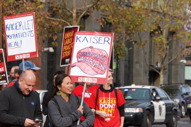 Oakland, Ca - 17 Aralık 2019 Broadway 'den One Kaiser' a yürüyen kimliği belirsiz sağlık görevlileri. Endişeler arasında düşük ücretler, Kaiser yöneticileri için yüksek maaş ve personel sıkıntısı yer alıyor.