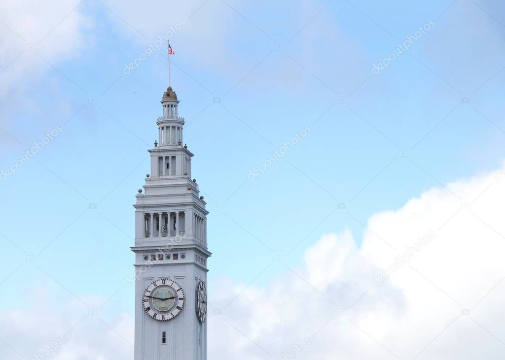 San Francisco Ferry Building clock tower with blue cloudy sky in background.