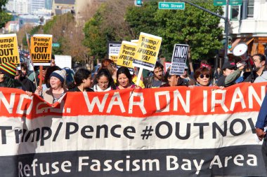 San Francisco, CA - Jan 11, 2020: Unidentified people protesting the Trump Pence presidency, demanding No War in Iran. Marching in the streets downtown blocking traffic.