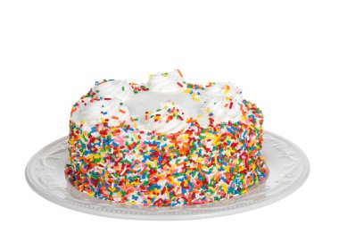 Krem şantili vanilyalı kek, beyaz üzerine izole edilmiş porselen bir tabakta şeker parçacıkları serpiştirilmiş. Doğum günü partisi teması