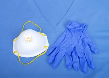 Üst görünüm düz bir N95 tıbbi sınıf maske ve üzerinde mavi lateks eldivenler var.