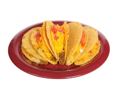 Beyaz üzerine izole edilmiş kırmızı bir tabakta beş tane çıtır taco. Popüler Amerikan Meksika yemekleri. Yukarıdan bir açıyla bakıldığında.