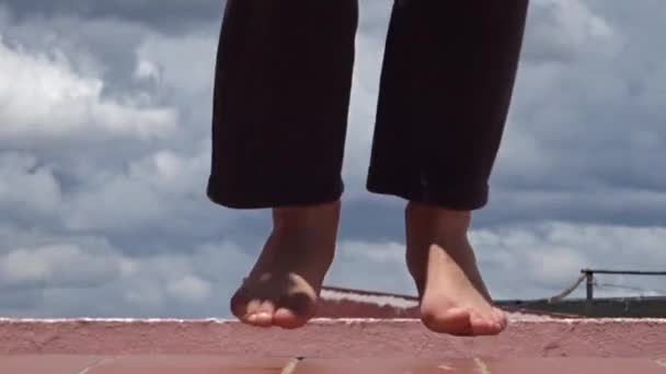 Close-up van blote voeten van een klein meisje dat is springtouw. — Stockvideo