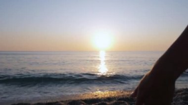 İki kadın gün batımında el ele tutuşuyorlar..